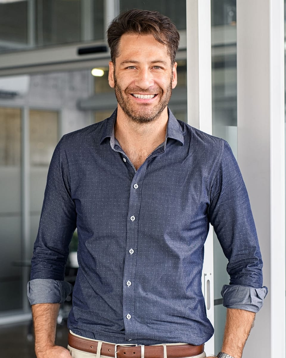 Hombre bien vestido mayor viendo a la cámara mientras sonríe